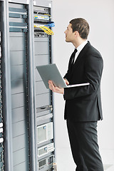 Image showing businessman with laptop in network server room