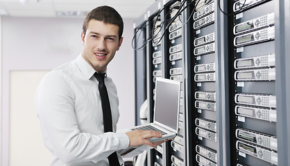 Image showing businessman with laptop in network server room