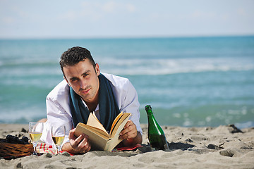 Image showing man reading book at beach