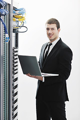 Image showing businessman with laptop in network server room