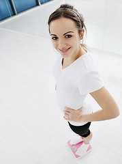 Image showing happy diet concept with young woman on pink scale