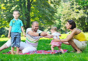 Image showing happy young couple with their children have fun at park