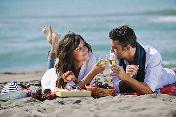 Image showing young couple enjoying  picnic on the beach