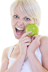 Image showing happy  young  woman eat green apple isolated  on white