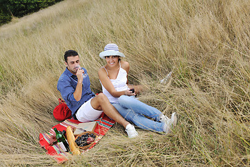 Image showing happy couple enjoying countryside picnic in long grass