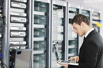 Image showing businessman with laptop in network server room