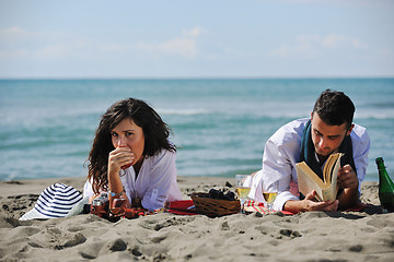 Image showing young couple enjoying  picnic on the beach