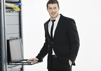 Image showing businessman with laptop in network server room