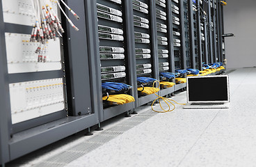 Image showing businessman with laptop in network server room