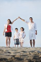 Image showing family on beach showing home sign