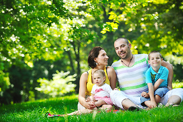 Image showing happy young couple with their children have fun at park