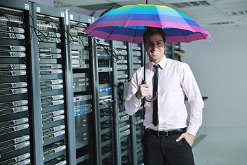 Image showing businessman hold umbrella in server room