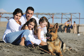 Image showing happy family playing with dog on beach