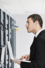 Image showing businessman with laptop in network server room