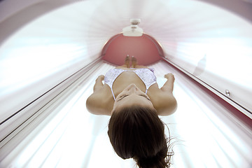 Image showing Beautiful young woman tanning in solarium