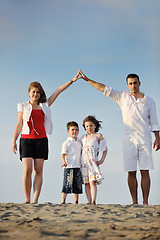 Image showing family on beach showing home sign