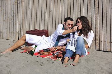 Image showing young couple enjoying  picnic on the beach