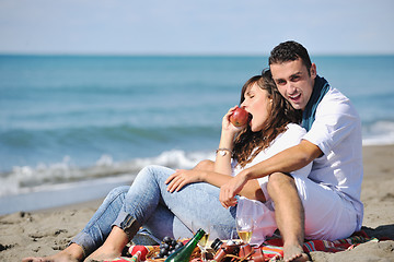 Image showing young couple enjoying  picnic on the beach