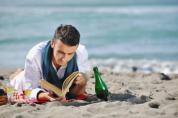 Image showing man reading book at beach