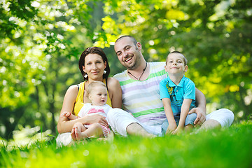 Image showing happy young couple with their children have fun at park