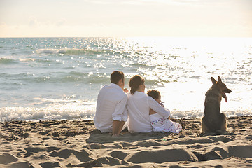 Image showing happy family playing with dog on beach