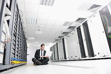 Image showing businessman with laptop in network server room