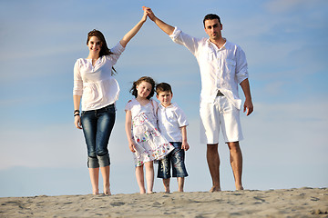 Image showing family on beach showing home sign