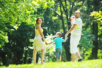 Image showing happy young couple with their children have fun at park