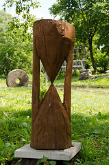 Image showing Wooden sandglass imitation closeup and millstone 