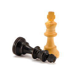 Image showing Black chess king lie near winner white legs 