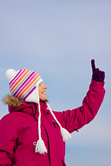 Image showing Girl in witer clothes pointing upwards