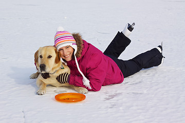 Image showing Girl with her dog posing in snow