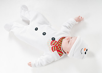 Image showing Baby boy in snowman costume lying on the floor