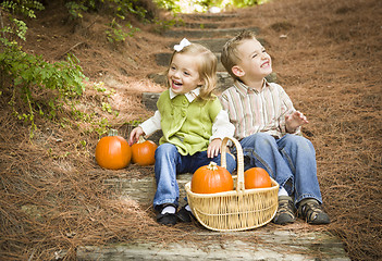 Image showing Brother and Sister Children Sitting on Wood Steps with Pumpkins