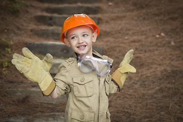 Image showing Adorable Child Boy with Big Gloves Playing Handyman Outside