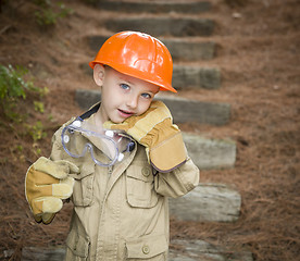 Image showing Adorable Child Boy with Big Gloves Playing Handyman Outside