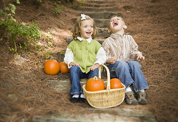 Image showing Brother and Sister Children Sitting on Wood Steps with Pumpkins
