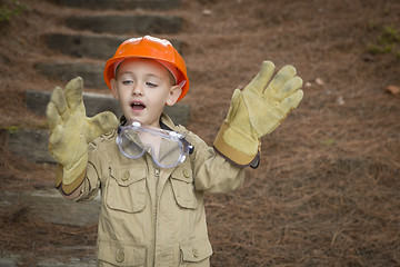 Image showing Adorable Child Boy with Big Gloves Playing Handyman Outside