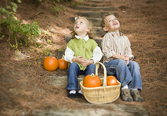 Image showing Brother and Sister Children on Wood Steps with Pumpkins Singing