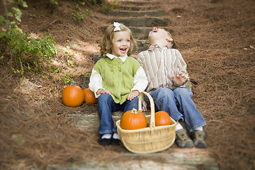 Image showing Brother and Sister Children Sitting on Wood Steps with Pumpkins