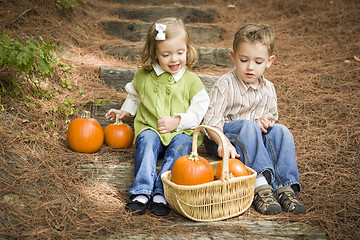 Image showing Brother and Sister Children Sitting on Wood Steps with Pumpkins