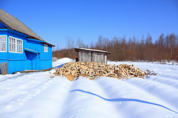 Image showing damp firewood near rural building 