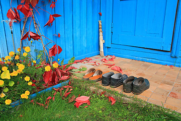 Image showing aging footwear on porch of the rural building