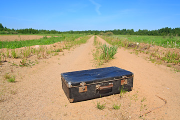 Image showing old valise on rural road 