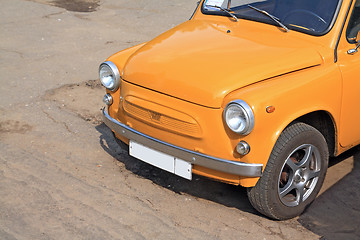 Image showing old orange car on town street