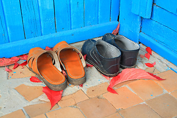 Image showing aging footwear on porch of the rural building