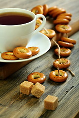 Image showing Cup of tea and small bagels with poppy seeds.