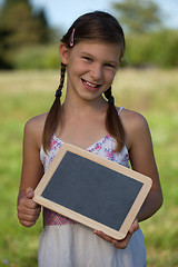 Image showing Young girl holding a small blackboard