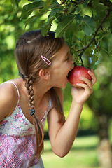 Image showing Girl biting into an apple