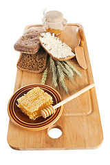 Image showing honey, spike and bread on table 